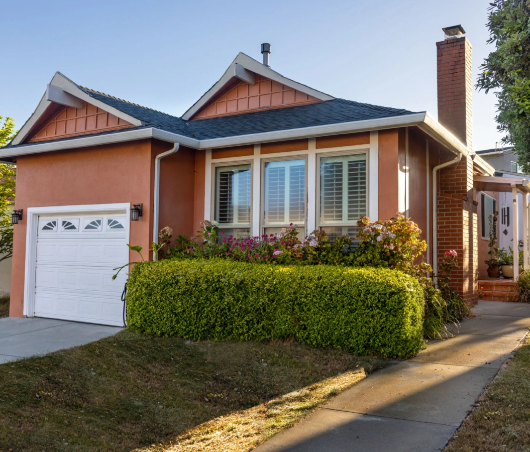Single-story house with manicured front yard.
