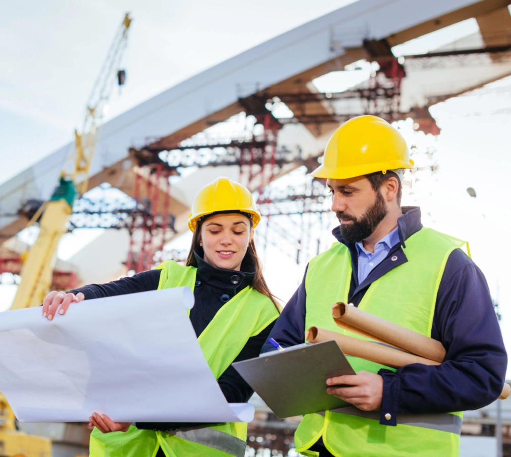 Construction workers reviewing plans at site.
