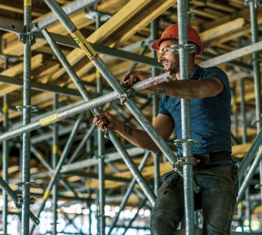 Construction worker on scaffolding with tools.